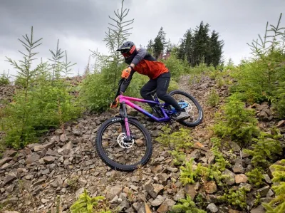 Mies pyöräilee mäkeä alas