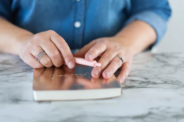 A man is holding a notebook on a table